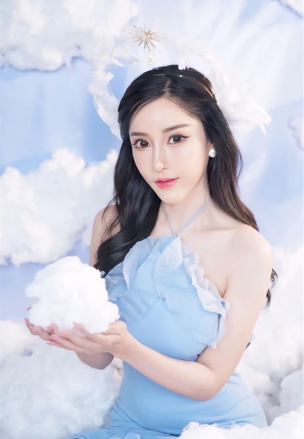 ภัทรภร สุภัทรศักดา ในชุดเกาะอกสีฟ้ากับฉากก้อนเมฆ