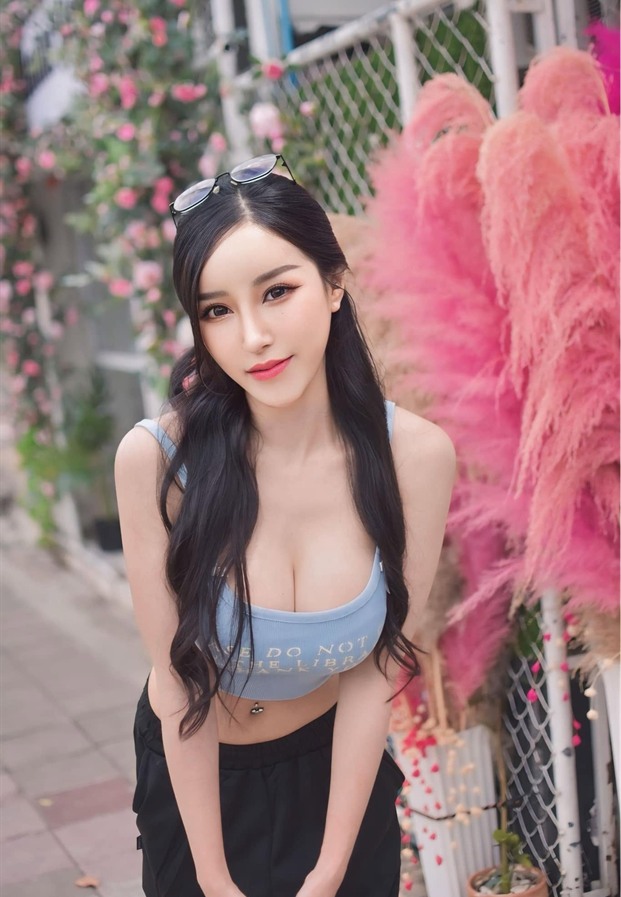 ภัทรภร สุภัทรศักดา ยืนข้างขนนกตกแต่งสีชมพู