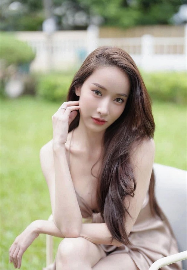 มุก พิชานา นั่งกลางสนามหญ้าในชุดโทนครีมชมพู
