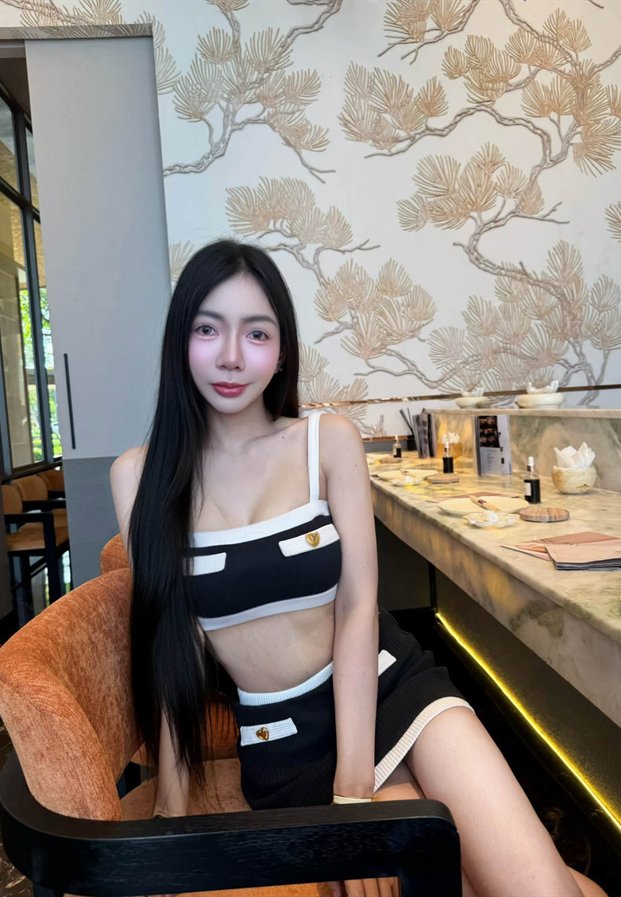 ซิดนีย์ ภัทนิยา ในชุดครอปสีดำขาว นั่งริมเคาน์เตอร์บาร์