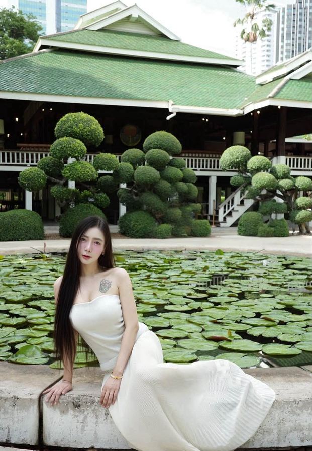 ซิดนีย์ ในชุดยาวสีครีมริมบ่อบัว