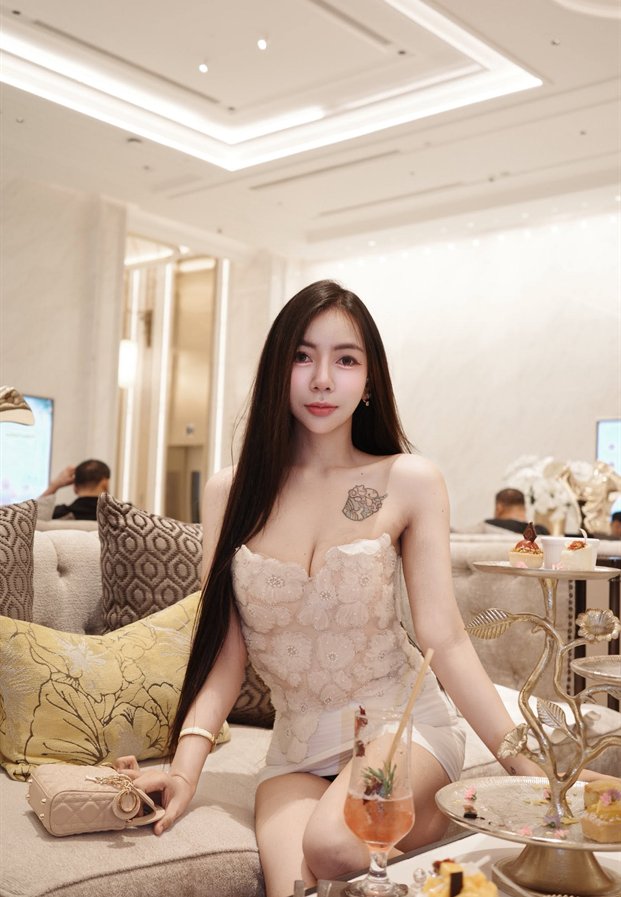 ซิดนีย์ ภัทนิยา ในชุดลูกไม้สีเบจกับชุดน้ำชา