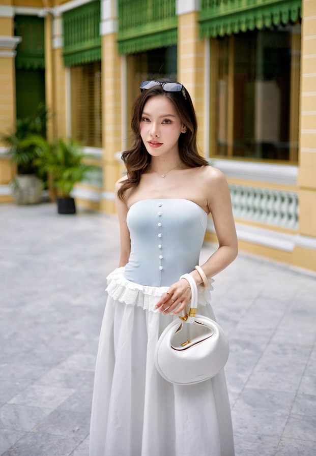 หยก ยืนถือกระเป๋าถักหน้าประตูไม้สีเขียว