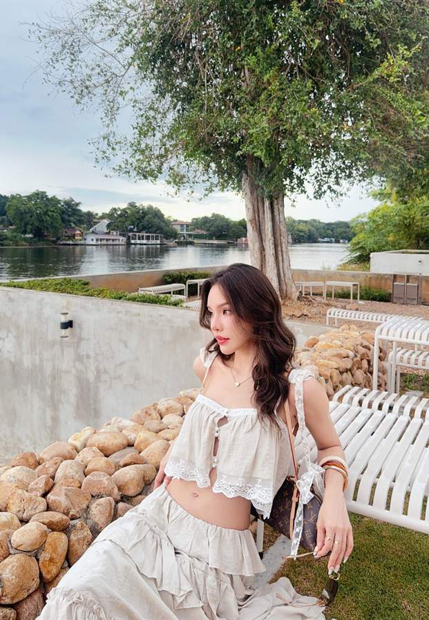 Yok Phatchaya ยืนริมแม่น้ำกับวิวภูเขายามเย็น