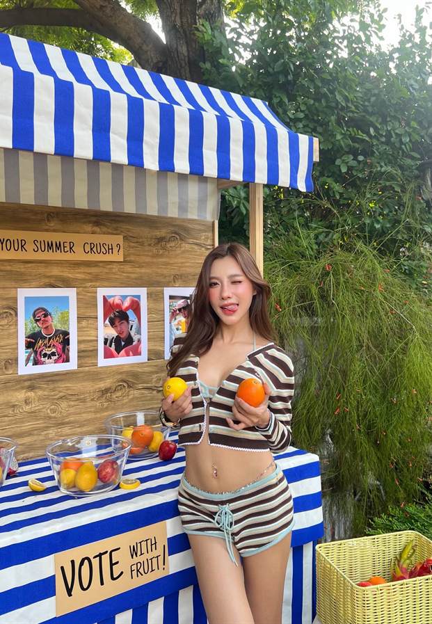ได๋ได๋ ธันย์ธนิดา ถือผลไม้ที่ซุ้มลายทางสีน้ำเงินขาว