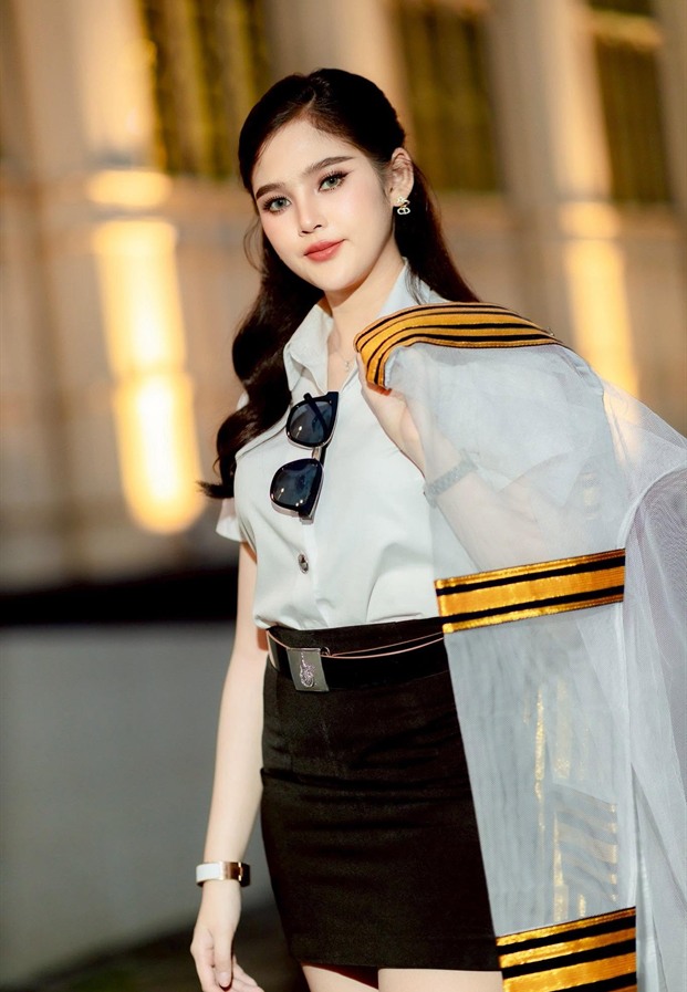 ขนิษฐา กนกนาค ในชุดเครื่องแบบขาวกับผ้าคลุมไหล่
