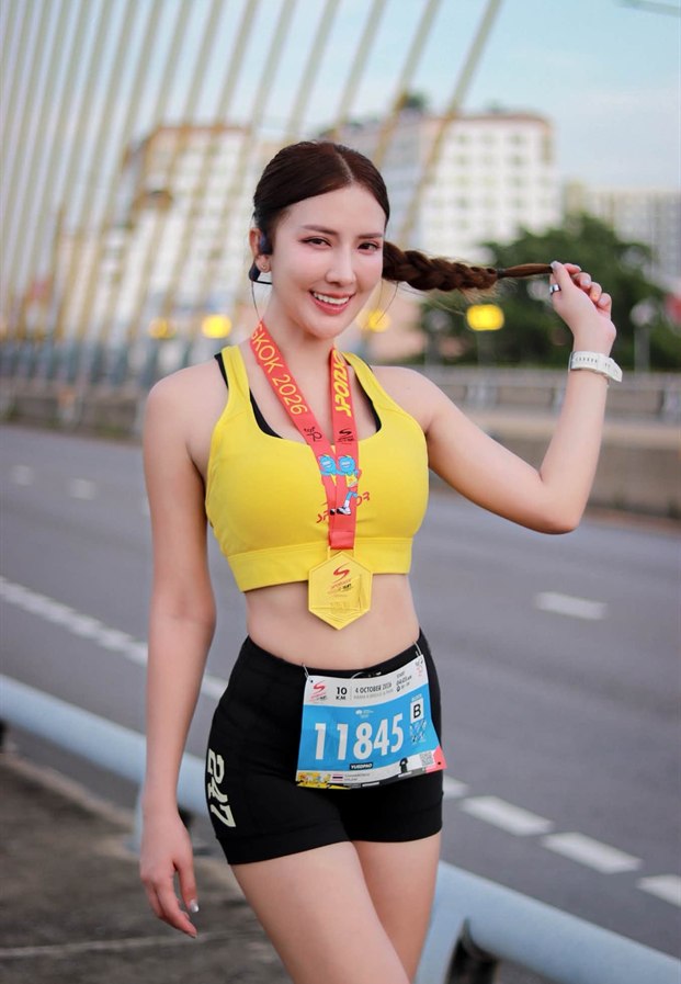 Chananchida Kulsiri คล้องเหรียญงานวิ่งบนสะพานในชุดสีเหลือง