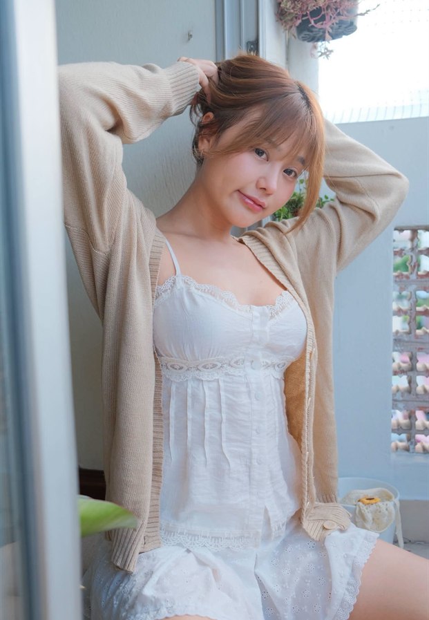 ยืนพิงหน้าต่างในเดรสลูกไม้สีขาว