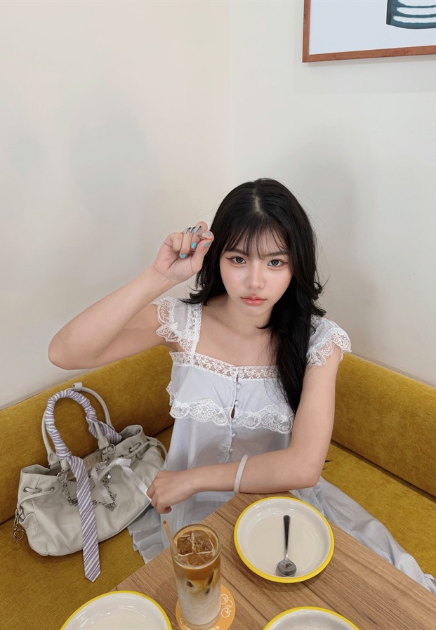 Prim Benjawan นั่งโต๊ะคาเฟ่โซฟาสีเหลืองกับกาแฟเย็น